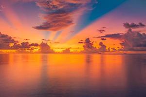 belo pôr do sol mar oceano. cores vibrantes e suaves, luz mágica. céu de nuvens fantásticas, reflexo na água. conceito de tempo romântico de férias em tropical. energia positiva, inspiração de meditação foto