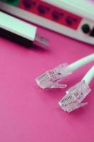 roteador de internet, adaptador wi-fi usb portátil e plugues de cabo de internet estão em um fundo rosa brilhante. itens necessários para internet foto