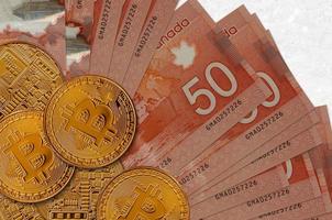 50 notas de dólares canadenses e bitcoins dourados. conceito de investimento em criptomoeda. mineração ou negociação de criptomoedas foto