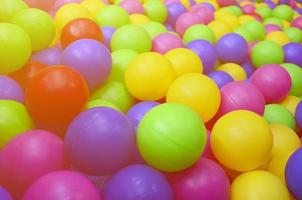 muitas bolas de plástico coloridas em uma piscina infantil em um playground. padrão de close-up foto