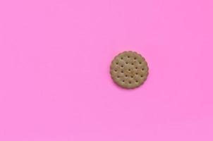 biscoito em miniatura em um fundo rosa. conceito mínimo na moda de comida e sobremesa. postura plana abstrata, vista superior foto