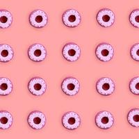 muitos pequenos donuts de plástico encontram-se em um fundo colorido pastel. padrão mínimo de postura plana. vista do topo foto