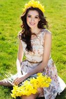 menina feliz e sorridente com flores amarelas foto