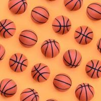 muitas pequenas bolas laranja para jogo de esporte de basquete estão no fundo de textura de papel de cor laranja pastel de moda em conceito mínimo foto