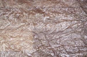 textura da superfície de celofane amassado branco transparente na luz solar. conceito de materiais para embalagem, proteção do produto contra danos foto