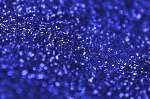 lantejoulas decorativas azuis. imagem de fundo com luzes de bokeh brilhantes de pequenos elementos foto
