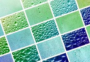uma colagem de diversos fragmentos de vidro, decorados com gotas de chuva do condensado. tons de primavera com cores verdes e azuis foto