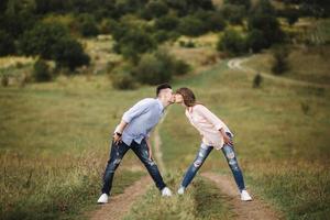 casal jovem louco emocionalmente se divertindo, beijando e se abraçando ao ar livre. amor e ternura, romance, família, emoções, diversão. se divertindo juntos foto