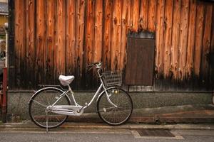 prefeitura de kyoto, kansai, japão - 22 de novembro de 2019 - bicicleta no fundo da antiga casa de madeira no distrito de higashiyama em kyoto foto