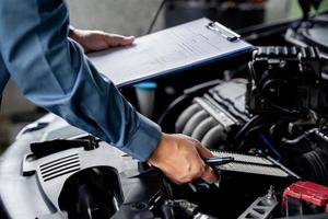 técnico segure e verifique o filtro de ar do motor na sala de máquinas e verifique o trabalho de serviço de lista na garagem, conceito de serviço de carro