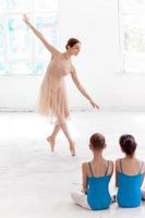 duas pequenas bailarinas dançando com o professor pessoal de balé na dança foto