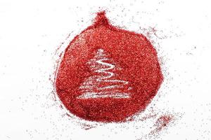 árvore desenhada dedo no fundo de confete vermelho brilhante. bola de brinquedo de natal foto