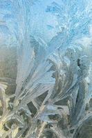 janela de inverno congelado com textura de padrão de geada de gelo brilhante. símbolo de maravilha de natal, abstrato. extremo norte de baixa temperatura, neve de gelo natural em vidro gelado, clima frio de inverno ao ar livre. foto
