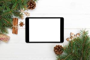 tablet digital simulado com decorações rústicas de fundo de madeira de natal para apresentação de aplicativos. vista superior com espaço de cópia foto