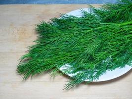 um monte de endro em uma tábua de corte. produto útil. verdes na mesa da cozinha. ingrediente do almoço vegetariano. foto