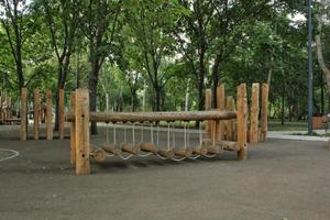 ponte de corda no playground de madeira de crianças modernas ao ar livre em um parque público da cidade. descanso de estilo de vida ecologicamente correto e conceito infantil de infraestrutura ambiental de segurança para crianças. aventura engraçada