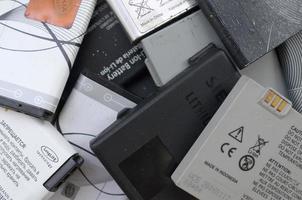 kharkov, ucrânia - 12 de maio de 2022, monte de baterias de celular usadas antigas. reciclagem de eletrônicos foi vendido no mercado barato foto