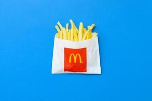 carcóvia. ucrânia - 17 de maio de 2022 batatas fritas do mcdonald em pequeno saco de papel em fundo azul brilhante foto