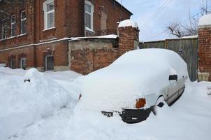 kharkov, ucrânia - 4 de janeiro de 2022 um carro estacionado sob uma espessa camada de neve. consequências de uma forte e inesperada nevasca na ucrânia foto