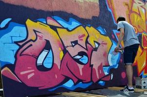 carcóvia. ucrânia - 2 de maio de 2022 festival de artes de rua. jovens desenham grafite em paredes de madeira portáteis no centro da cidade. o processo de pintura em paredes com latas de aerossol foto
