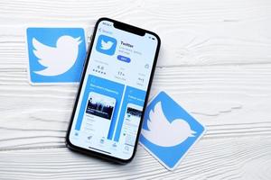 carcóvia. ucrânia - ícone do twitter de 2 de maio de 2022 e aplicativo da loja de aplicativos na tela de exibição do iphone 12 pro na mesa branca foto