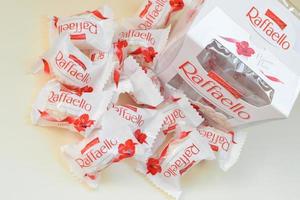 carcóvia. ucrânia - 17 de maio de 2022 raffaello doces em fundo bege. raffaello é um doce esférico de amêndoa de coco que o fabricante italiano ferrero trouxe ao mercado em 1990 foto