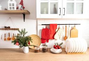 o conceito de decoração de ano novo de uma cozinha moderna em cores claras. vista frontal da bancada com utensílios de cozinha e decorações foto