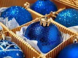 uma caixa de natal com bolas de natal azuis e presentes, bugigangas de natal. preparando para o feriado foto