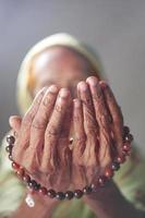close-up da mão de uma mulher idosa rezando no ramadã foto