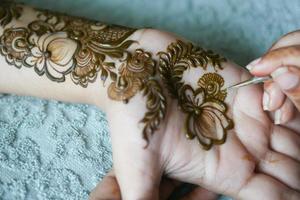 mulheres aplicando henna na mão foto
