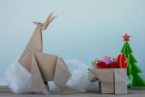 conceito origami o papel é uma rena, caribu se preparando para dar presentes às crianças no dia de natal. foto