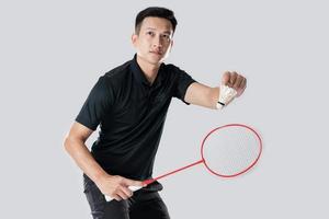 um jogador de badminton em roupas esportivas está segurando uma raquete e peteca foto