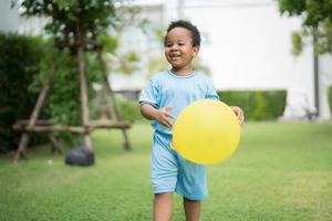 menino bonitinho com balões no parque em um dia claro. foto