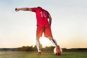 jogador de futebol jogando bola no estádio ao ar livre. foto