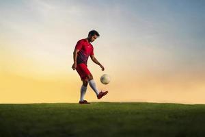 jogador de futebol jogando bola no estádio ao ar livre. foto