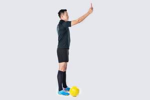 retrato de corpo inteiro de um árbitro de futebol dando um cartão vermelho isolado. foto