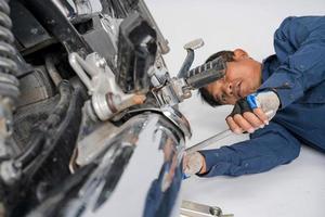 as pessoas estão consertando uma motocicleta use uma chave inglesa e uma chave de fenda para trabalhar foto