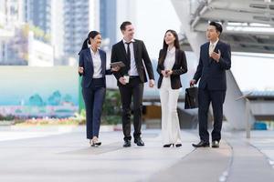 empresários andando e conversando uns com os outros na frente do escritório moderno foto