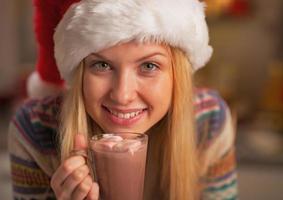 adolescente feliz com chapéu de Papai Noel com uma xícara de chocolate