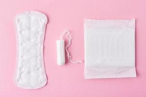absorvente e tampão menstrual em um fundo rosa foto