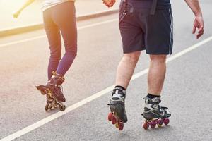 casal feliz andando de patins de mãos dadas na cidade foto