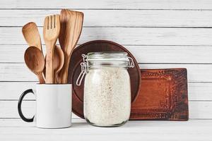 utensílios de cozinha em copo e prato marrom em branco foto