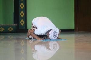 jovem muçulmano asiático rezando na mesquita foto