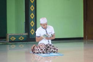 jovem muçulmano asiático rezando na mesquita foto