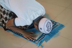 jovem muçulmano asiático rezando na mesquita foto
