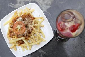 batatas fritas com cobertura de queijo foto