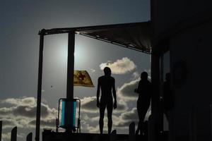 rio de janeiro, rj, brasil, 2022 - pessoas em silhueta assistem o pôr do sol na rocha do arpoador, praia de ipanema foto