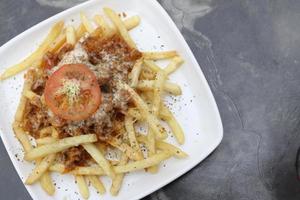 batatas fritas com cobertura de queijo foto