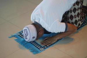 jovem muçulmano asiático rezando na mesquita foto