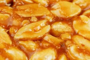 kozinaki de grãos de amendoim torrados e dourados como pano de fundo, textura. tiro macro, close-up. lugar para texto foto